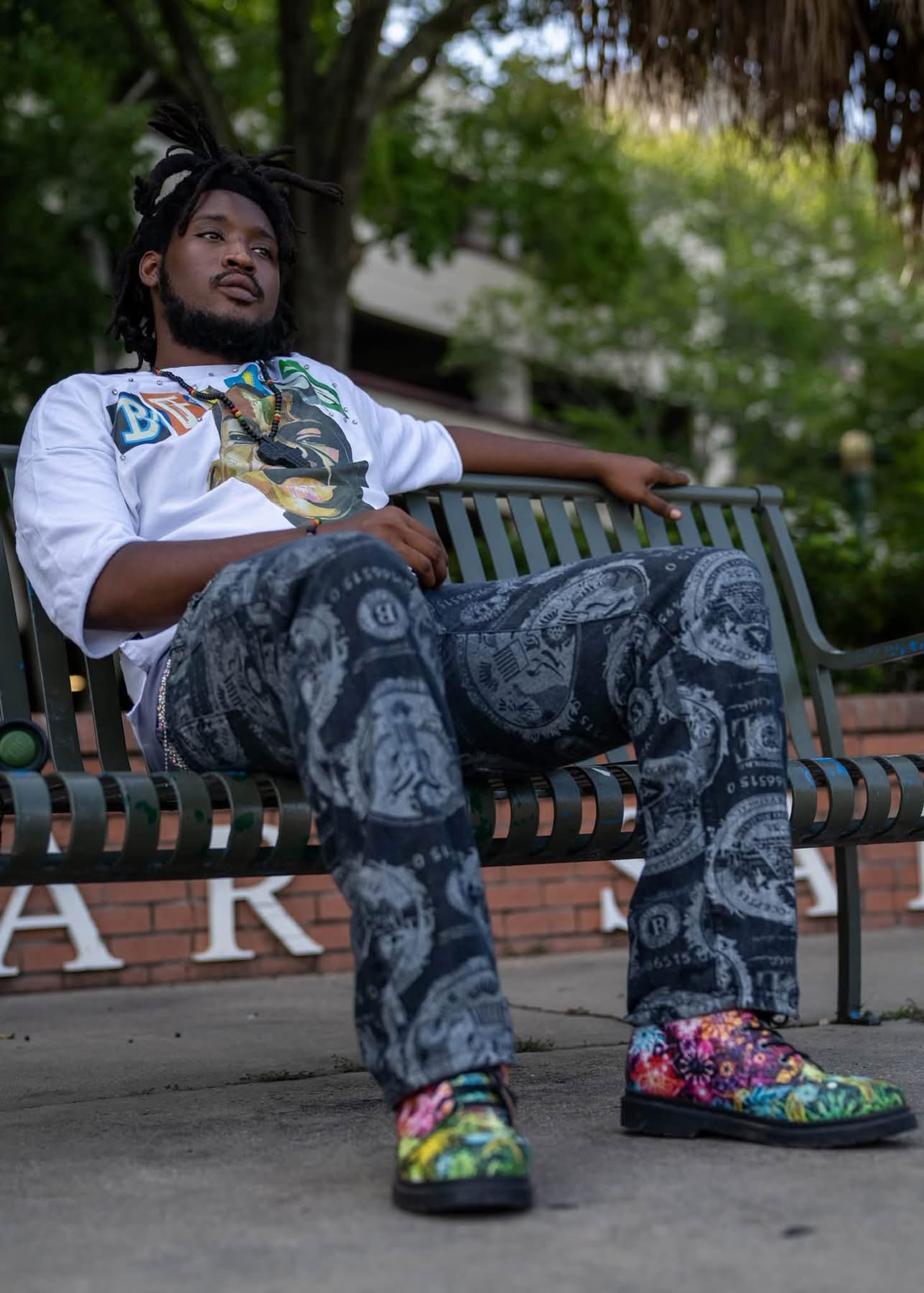 Gee Scott seated outdoors on a bench.